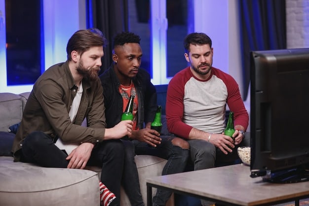 A group of League of Legends players strategizing during a live club event, with team members discussing tactics and reviewing gameplay on a monitor.