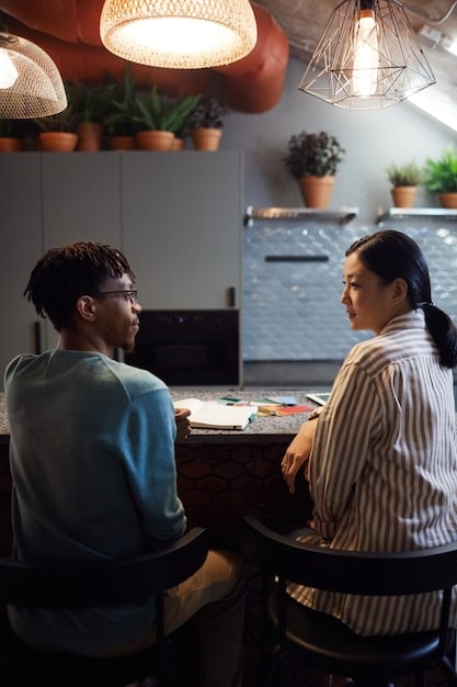 A mediator facilitating a discussion between two colleagues in a bright office. The atmosphere is calm and focused, emphasizing active listening and problem-solving.