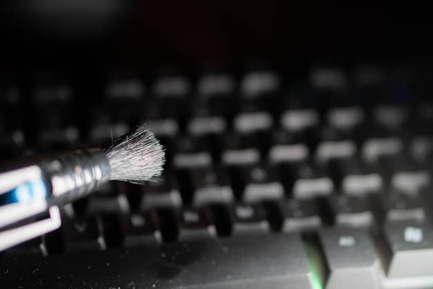 Side view of a mechanical keyboard, showing the key switches and exposed plate, with a small brush being used to clean between components.