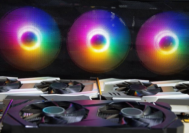 A close-up shot of a high-end graphics card (GPU) illuminated by RGB lighting, showcasing its powerful components, with a blurred ultrawide monitor screen in the background.