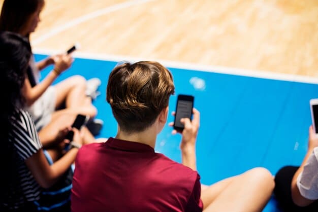 A young mobile esports player actively engaged in a collegiate tournament, surrounded by teammates and coaches, showcasing the structured path for talent development.