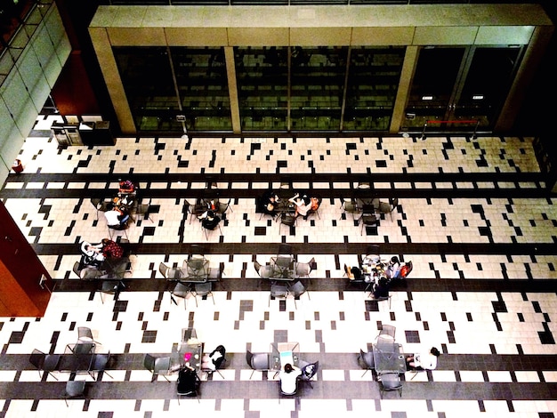 An aerial view of a large convention center floor being set up for an esports event, showing the skeletal structure of a main stage, rows of chairs, and various technicians at work amidst power cables and equipment crates.