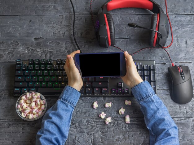 A person's hands using a gaming laptop on a desk with several cooling pads displayed around it. The image conveys the process of selecting the best cooling solution. Showcasing that 'Gaming Laptop Cooling Pads: Do They Really Reduce Temperatures by 10 Degrees?'.